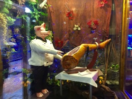 Look carefully at this caricature—the pig is doing the carving and the leg is human.