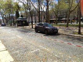 Not sure why cars were blocked off like this but  a large number of streets had cars and parking spaces blocked off on this day which was a religious holiday for many (Good Friday).