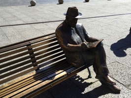 Statue of Gaudi on bench outside Casa Botines.